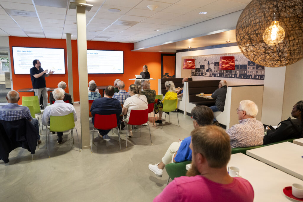 Toine spreekt een groep huurders toe bij de Huurdersconsultatie van Stichting HBL